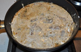 Сметану хорошо вымешиваем со сливками и вливаем к мясу, добавляем перца. Кипение должно быть еще слабее, тушение продолжаем до той поры, когда говядина станет очень мягкой  (15-30 минут).