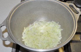 Ставим латку (посуду для тушения) с маслом разогреваться на сильном огне, рубим лук половинками или четвертинками колец, закладываем в латку и обжариваем 4-5 минут.