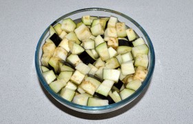 Все овощи моем и чистим. Баклажаны нарезаем кубиками, заливаем подсоленной водой и оставляем минимум на 20 минут, после чего избавляем от жидкости.