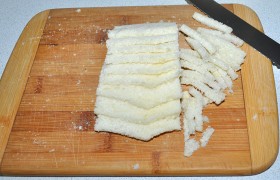 О  панировке  заботимся еще до начала готовки. Срезаем с батона корки, полученный белый «кирпичик» отправляем в морозилку минут на 20-30. Затем нарезаем тонкими, по 4 мм, ломтиками. И снова немного подержим в морозилке. Теперь нарезаем его соломкой, что несложно. 