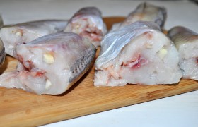 Когда рыбка немного обсохла –  нашпиговываем  ее кусочками чеснока, нарезанными вдоль. Рыба стала такой сочной и мягкой, что чеснок легко вдавливается пальцами.