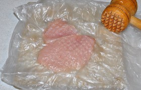 Каждый кусок помещаем в пищевой пакет и легко (мясо очень нежное) отбиваем с одной стороны деревянным молотком. Так равняем толщину всех кусков филе.