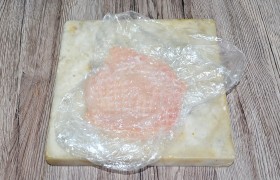  Отбиваем , поместив в пакет, деревянным кухонным молотком, расплющивая филе все больше. Делаем это несильными ударами, не спеша, добиваясь одинаковой толщины отбивных по всей поверхности, 6-7 мм. Это – одно из условий сочности отбивных. Отбивать начинаем, положив филе вверх той стороной, где есть пленочка. 