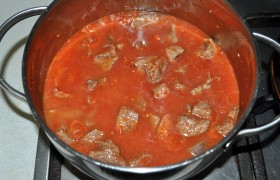 Выкладываем все мясо в кастрюлю (казан), приправляем солью, перцем, добавляем томатное пюре, заливаем горячей воды, так, чтобы соус почти накрывал мясо. После закипания на слабом огне тушим около часа, под крышкой. Если мы хотим, чтобы и свиные шкварки присутствовали в гуляше – добавляем их.
