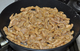 Закладываем все мясо в раскаленную сковороду, непрерывно помешивая, обжариваем мясные полоски 2-3 минуты.