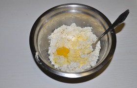 За это время размягчится и сливочное масло. Добавляем к творогу масло, вбиваем яйцо.