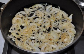 А в сковородку засыпаем шинкованный половинками колец лук,  пассеруем  6-7 минут, помешивая. 