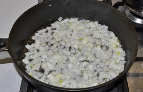 Вливаем в сковороду масло, на огне больше среднего сильно разогреваем. Засыпаем нарезанный средним кубиком лук, пассеруем его, помешивая, 5 минут.