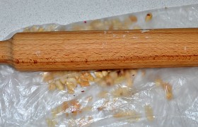 Орехи (сорт на свой выбор) слегка обжариваем на сухой сковородке (по желанию), дробим на мелкие кусочки в пакете с помощью скалки или делаем это в блендере.