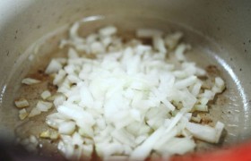 Сливаем почти все масло. Засыпаем лук и чеснок, помешивая, обжариваем около минуты-двух. 