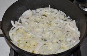 Ставим растительное масло разогреваться в толстостенной сковороде, чистим луковицы, нарезаем. Добавляем половину сливочного масла, чеснок и  пассеруем  на среднем огне 9-10 минут, до мягкости и золотистого оттенка.